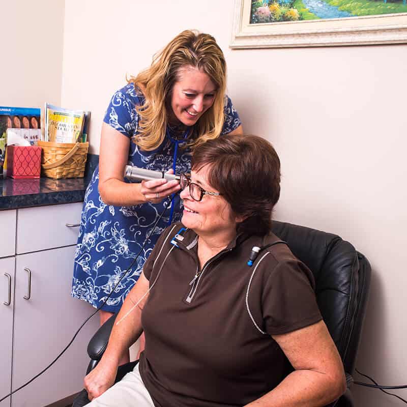 specialist checking patient's ears with an otoscope