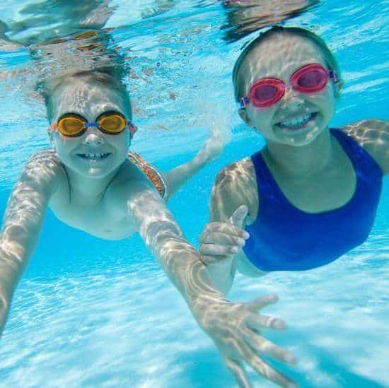 children swimming in a pool with swim molds